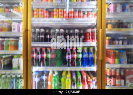 Supermarkt-24-Stunden-Geschäft Kühlschränke mit alkoholfreien Getränkeflaschen auf Regalen abstrakten Unschärfe Hintergrund Stockfoto