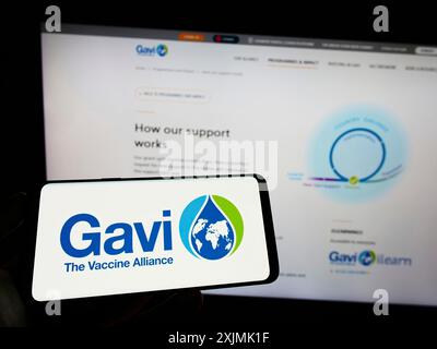 Stuttgart, Deutschland, 07-31-2022: Person mit Handy mit Logo der Gesundheitspartnerschaft Gavi, die Impfallianz auf dem Bildschirm vor der Webseite. Stockfoto