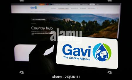 Stuttgart, Deutschland, 07-31-2022: Person mit Handy mit Logo der Gesundheitspartnerschaft Gavi, die Impfallianz auf dem Bildschirm vor dem Web Stockfoto