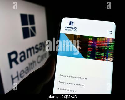 Stuttgart, Deutschland, 27.08.2022: Person, die ein Mobiltelefon hält, mit Webseite des australischen Unternehmens Ramsay Health Care Limited auf dem Bildschirm mit Logo. Konzentrieren Sie sich auf Stockfoto