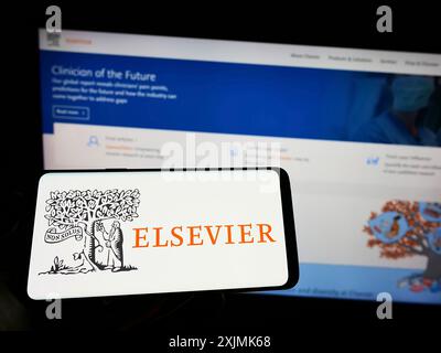 Stuttgart, Deutschland, 07-31-2022: Person mit Handy mit Logo des akademischen Verlags Elsevier auf dem Bildschirm vor der Business-Website. Stockfoto
