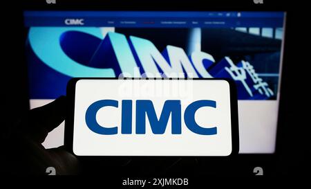 Stuttgart, Deutschland, 28.08.2022: Person, die ein Smartphone mit dem Logo von China International Marine Containers (CIMC) auf dem Bildschirm vor der Website hält. Stockfoto