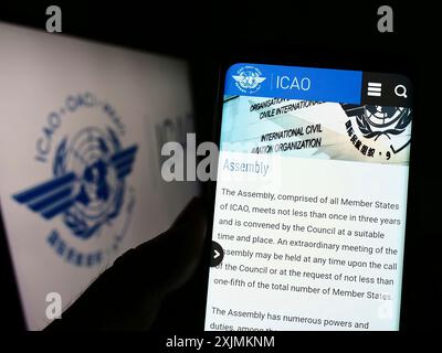 Stuttgart, Deutschland, 09.04.2022: Person, die ein Mobiltelefon hält, mit Website der Internationalen Zivilluftfahrt-Organisation (ICAO) auf dem Bildschirm mit Logo. Fokus Stockfoto