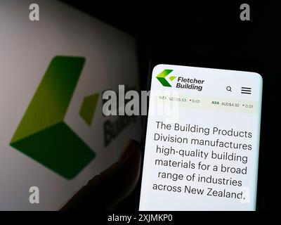 Stuttgart, Deutschland, 09.04.2022: Person, die ein Mobiltelefon hält, mit Website des Bauunternehmens Fletcher Building Limited auf dem Bildschirm mit Logo. Konzentrieren Sie sich auf Stockfoto
