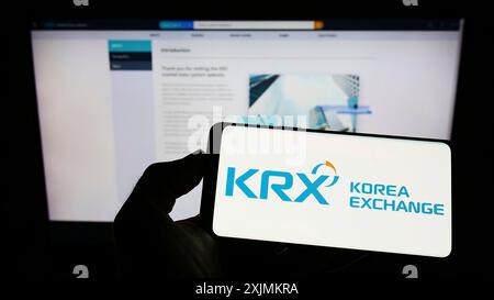 Stuttgart, Deutschland, 28.08.2022: Person mit Mobiltelefon mit Logo des Finanzmarktplatzes Korea Exchange (KRX) auf dem Bildschirm vor dem Unternehmen Stockfoto