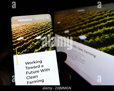 Stuttgart, Deutschland, 09-08-2022: Person, die ein Smartphone hält, mit Website und Logo der Firma Zimeno Inc. (Monarch-Traktor) auf dem Bildschirm mit Monitor. Stockfoto
