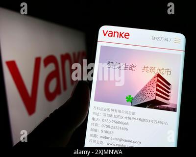 Stuttgart, Deutschland, 22.09.2022: Person, die ein Smartphone hält, mit Webseite der chinesischen Immobiliengesellschaft Vanke Co. Ltd. Auf dem Bildschirm vor dem Logo. Stockfoto