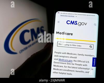 Stuttgart, Deutschland, 22.09.2022: Person mit Mobiltelefon mit Webseite der Zentren für Medicare und Medicaid-Dienste (CMS) auf dem Bildschirm mit Logo. Fokus Stockfoto