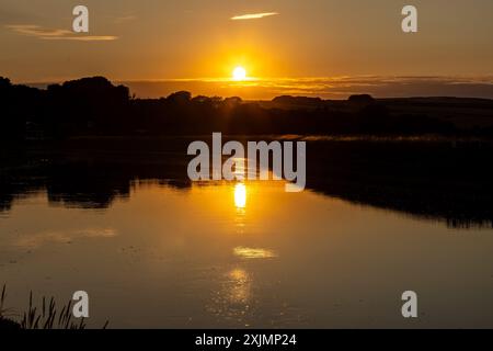 Ein idyllischer Sonnenuntergang über dem Fluss Ouse in der Nähe von Piddinghoe in Sussex Stockfoto