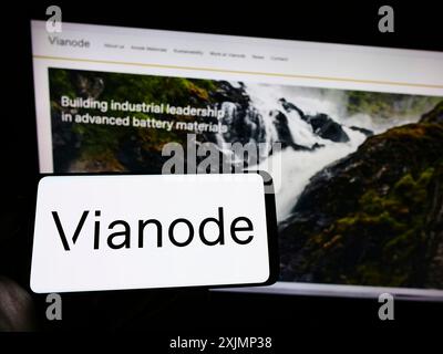 Stuttgart, Deutschland, 25.09.2022: Person, die ein Mobiltelefon mit dem Logo des norwegischen Batteriematerialunternehmens Vianode auf dem Bildschirm vor dem Geschäft hält Stockfoto