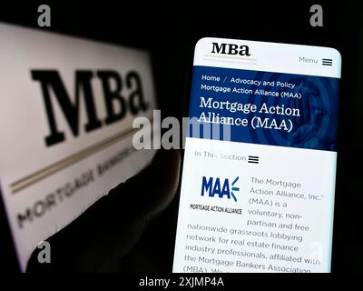 Stuttgart, Deutschland, 25.09.2022: Person, die ein Mobiltelefon hält, mit Webseite der Organisation Mortgage Bankers Association (MBA) auf dem Bildschirm mit Logo. Fokus Stockfoto