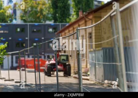 PRODUKTION - 19. Juli 2024, Hessen, Frankfurt/Main: Baumaschinen auf einem Schulgelände in der Launitzstraße. Die Klassen werden hier auch in Containern abgehalten. Die Frankfurter Schulen platzen aus den Nähten und viele müssen saniert werden. Die Stadt will daher eine Milliarde Euro in den Bau neuer Bildungseinrichtungen investieren. Foto: Andreas Arnold/dpa Stockfoto