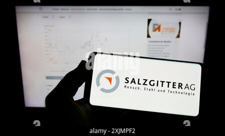 Stuttgart, 10.01.2022: Handybesitzer mit Logo des deutschen Stahlunternehmens Salzgitter AG auf dem Bildschirm vor der Business-Webseite. Stockfoto