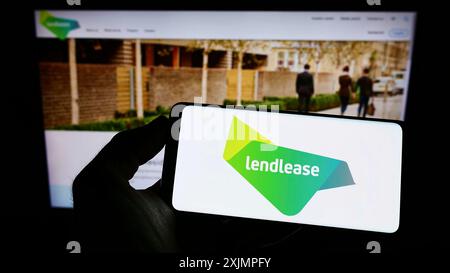 Stuttgart, Deutschland, 10.01.2022: Person, die ein Smartphone hält, mit dem Logo der Immobilienfirma Lendlease Corporation Limited auf dem Bildschirm vor dem Bildschirm Stockfoto