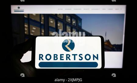 Stuttgart, Deutschland, 25.09.2022: Person, die ein Smartphone mit dem Logo des Bauunternehmens Robertson Group Limited auf dem Bildschirm vor der Website hält. Stockfoto
