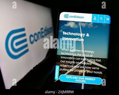 Stuttgart, Deutschland, 10.09.2022: Person, die ein Mobiltelefon hält, mit Webseite der US-amerikanischen Firma Consolidated Edison Inc. (ConEdison) auf dem Bildschirm mit Logo. Fokus Stockfoto