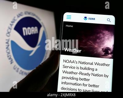 Stuttgart, Deutschland, 10.09.2022: Person, die ein Telefon hält, mit der Webseite der Nationalen Behörde für Ozeane und Atmosphäre (NOAA) auf dem Bildschirm mit Logo. Stockfoto