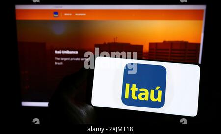 Stuttgart, 14.10.2022: Person, die ein Smartphone mit dem Logo des brasilianischen Unternehmens Itau Unibanco Holding S.A. auf dem Bildschirm vor der Website hält. Stockfoto