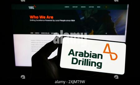 Stuttgart, Deutschland, 18.10.2022: Person, die ein Smartphone mit dem Logo der Saudi Business Arabian Drilling Company (ADC) auf dem Bildschirm vor der Website hält. Stockfoto