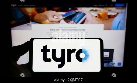 Stuttgart, 24.10.2022: Person mit Smartphone und Logo des australischen Fintech-Unternehmens Tyro Payments Limited vor dem Bildschirm Stockfoto