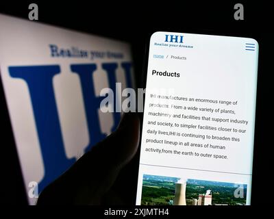 Stuttgart, 26.10.2022: Person, die ein Handy hält, mit Webseite des japanischen Ingenieurunternehmens IHI Corporation auf dem Bildschirm mit Logo. Konzentrieren Sie sich auf Stockfoto