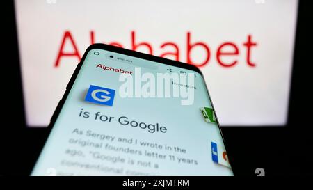 Stuttgart, Deutschland, 10-30-2022: Smartphone mit Website der US-Holding Alphabet Inc. (Google) auf dem Bildschirm vor dem Firmenlogo. Konzentrieren Sie sich auf Stockfoto