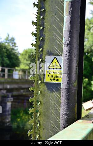 Anti-Climb-Spitzen und Warnschild auf der Fußgängerbrücke über den Fluss Dart an der Totnes Riverside Station. Stockfoto