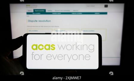 Stuttgart, Deutschland, 12.01.2022: Person, die ein Mobiltelefon mit dem Logo des Beratungs-, Schlichts- und Schiedsdienstes (ACAS) auf dem Bildschirm mit Web hält Stockfoto