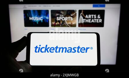 Stuttgart, Deutschland, 12.02.2022: Person, die ein Mobiltelefon mit dem Logo des US-amerikanischen Unternehmens Ticketmaster Entertainment Inc. Auf dem Bildschirm vor dem Geschäft hält Stockfoto