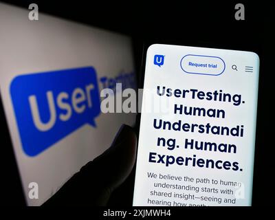 Stuttgart, Deutschland, 12.02.2022: Person, die ein Mobiltelefon hält, mit der Webseite des US-amerikanischen Customer Experience-Unternehmens UserTesting Inc. Auf dem Bildschirm mit Logo. Fokus Stockfoto