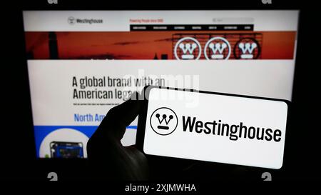 Stuttgart, Deutschland, 12.01.2022: Person, die ein Smartphone mit dem Logo des US-amerikanischen Unternehmens Westinghouse Electric Corporation auf dem Bildschirm vor der Website hält. Stockfoto