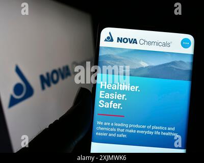 Stuttgart, Deutschland, 12.02.2022: Person, die ein Mobiltelefon hält, mit Website der kanadischen NOVA Chemicals Corporation auf dem Bildschirm vor dem Logo. Stockfoto