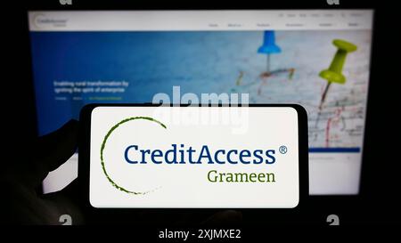 Stuttgart, Deutschland, 12.10.2022: Person, die ein Smartphone mit dem Logo des indischen Unternehmens CreditAccess Grameen Limited auf dem Bildschirm vor der Website hält. Stockfoto