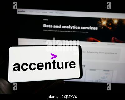 Stuttgart, 23.12.2022: Person mit Mobiltelefon mit Logo des IT-Unternehmens Accenture plc auf dem Bildschirm vor dem Geschäft Stockfoto