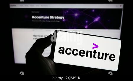 Stuttgart, 23.12.2022: Person mit Smartphone und Logo des IT-Unternehmens Accenture plc auf dem Bildschirm vor der Website. Stockfoto
