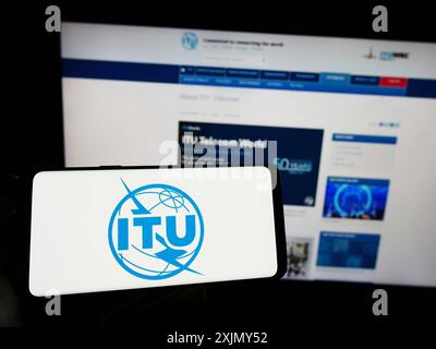 Stuttgart, Deutschland, 12-30-2022: Person, die ein Smartphone mit dem Logo der Internationalen Fernmeldeunion (ITU) auf dem Bildschirm vor der Website hält. Stockfoto