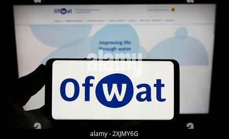 Stuttgart, Deutschland, 12.30.2022: Person, die ein Smartphone mit dem Logo der Behörde für die Regulierung der Wasserdienste (OFWAT) auf dem Bildschirm vor der Website hält. Stockfoto