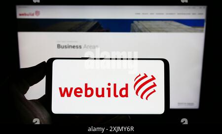Stuttgart, Deutschland, 12.30.2022: Person, die ein Smartphone mit dem Logo der italienischen Baufirma Webuild S.p.A. auf dem Bildschirm vor der Website hält. Stockfoto