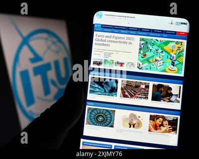 Stuttgart, Deutschland, 12-30-2022: Person, die ein Mobiltelefon hält, mit der Website der Internationalen Fernmeldeunion (ITU) vor dem Logo auf dem Bildschirm. Stockfoto