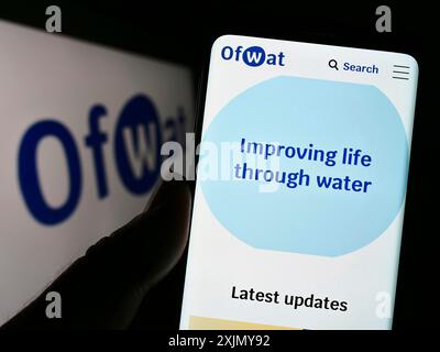Stuttgart, Deutschland, 12-30-2022: Person, die ein Mobiltelefon hält, mit Website der Behörde für Wasseraufsichtsbehörde (OFWAT) vor dem Logo auf dem Bildschirm. Stockfoto