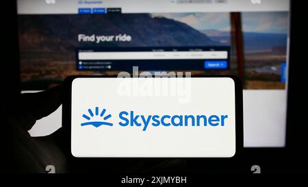 Stuttgart, Deutschland, 12.30.2022: Person, die ein Mobiltelefon mit dem Logo des Reiseforschungsunternehmens Skyscanner Ltd. Auf dem Bildschirm vor dem Geschäft hält Stockfoto