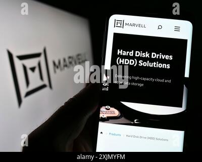 Stuttgart, Deutschland, 12-30-2022: Person, die ein Mobiltelefon hält, mit Webseite des US-amerikanischen Halbleiterkondurktorunternehmens Marvell Technology Inc. Auf dem Bildschirm mit Logo. Fokus Stockfoto
