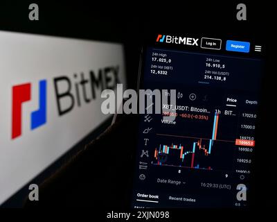 Stuttgart, Deutschland, 01-08-2023: Person, die ein Mobiltelefon hält, mit Webseite der Firma HDR Global Trading Limited (BitMEX) auf dem Bildschirm vor dem Logo. Stockfoto