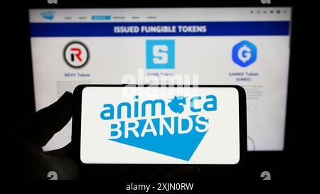 Stuttgart, 24.01.2023: Person mit Smartphone und Logo des Softwareunternehmens Animoca Brands Corporation Ltd. Auf dem Bildschirm Stockfoto