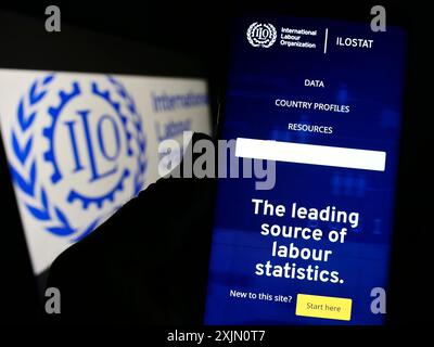 Stuttgart, Deutschland, 15.01.2023: Person, die ein Handy hält, mit einer Webseite der Internationalen Arbeitsorganisation der Vereinten Nationen (ILO) auf dem Bildschirm mit Logo. Fokus Stockfoto