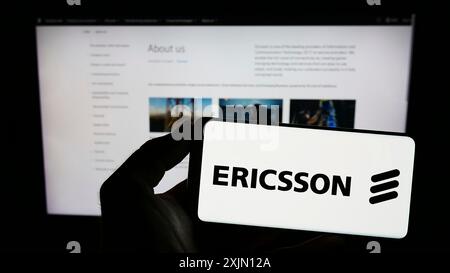 Stuttgart, Deutschland, 01.11.2023: Person, die ein Smartphone mit dem Logo des schwedischen Telekommunikationsunternehmens Ericsson auf dem Bildschirm vor der Website hält. Stockfoto