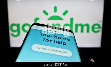 Stuttgart, Deutschland, 01.12.2023: Smartphone mit Website des Crowdfunding-Plattformunternehmens GoFundMe auf dem Bildschirm vor dem Business-Logo. Konzentrieren Sie sich auf Stockfoto