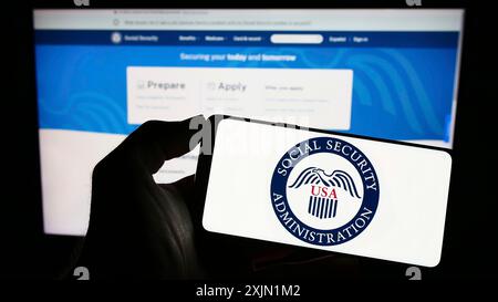 Stuttgart, Deutschland, 22.01.2023: Person, die ein Mobiltelefon mit dem Siegel der American Social Security Administration (SSA) auf dem Bildschirm vor dem Internet hält Stockfoto