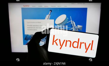 Stuttgart, 22.01.2023: Person, die ein Mobiltelefon mit dem Logo des Technologieunternehmens Kyndryl Holdings Inc. Auf dem Bildschirm vor dem Geschäft hält Stockfoto