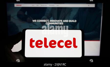 Stuttgart, Deutschland, 22.01.2023: Person, die ein Mobiltelefon mit dem Logo des Telekommunikationsunternehmens Telecel Group auf dem Bildschirm vor dem Unternehmen hält Stockfoto